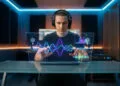 Tuto ElevenLabs : créer des voix de synthèse réalistes 39 Un jeune homme avec un casque audio manipulant une interface holographique futuriste représentant des ondes sonores.