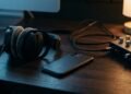 Casque audio, smartphone posé face contre le bureau et interface audio sous une lampe, pour l’analyse d’un enregistrement vocal