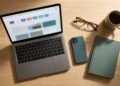 Bureau avec un ordinateur portable ouvert sur un navigateur aux nombreux onglets, à côté d’un smartphone, de lunettes et d’une tasse