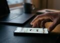 Fausse signature IA : ce que dit le droit quand une machine signe à votre place 5 Main approchant un smartphone affichant un dessin humoristique sur un réseau social