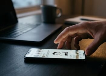 Main approchant un smartphone affichant un dessin humoristique sur un réseau social