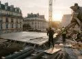 Chantier urbain au soleil couchant : coulage d’une dalle de béton près d’une toupie, armatures et grue