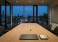 Salle de réunion vide au crépuscule, ordinateur portable fermé et carnet sur la table